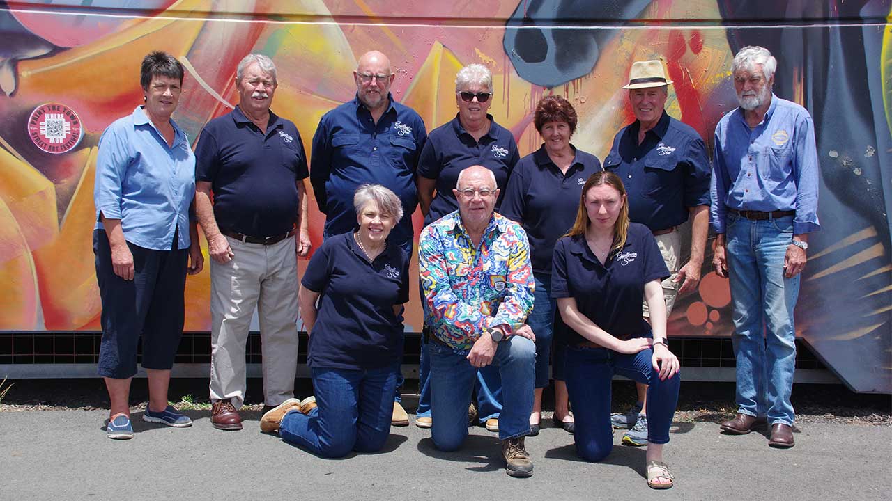 A group portrait of the RAS Foundation Community Futures Grant recipients standing before a colourful mural backdrop outdoors.
