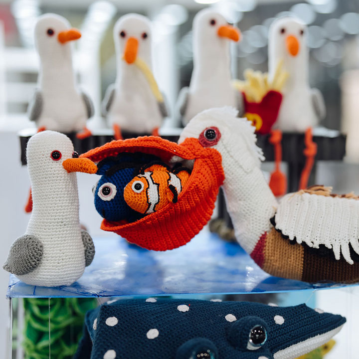 Crochet animal toys including seagulls and a pelican with fish, displayed on a table at the Sydney Royal Arts & Crafts Show.