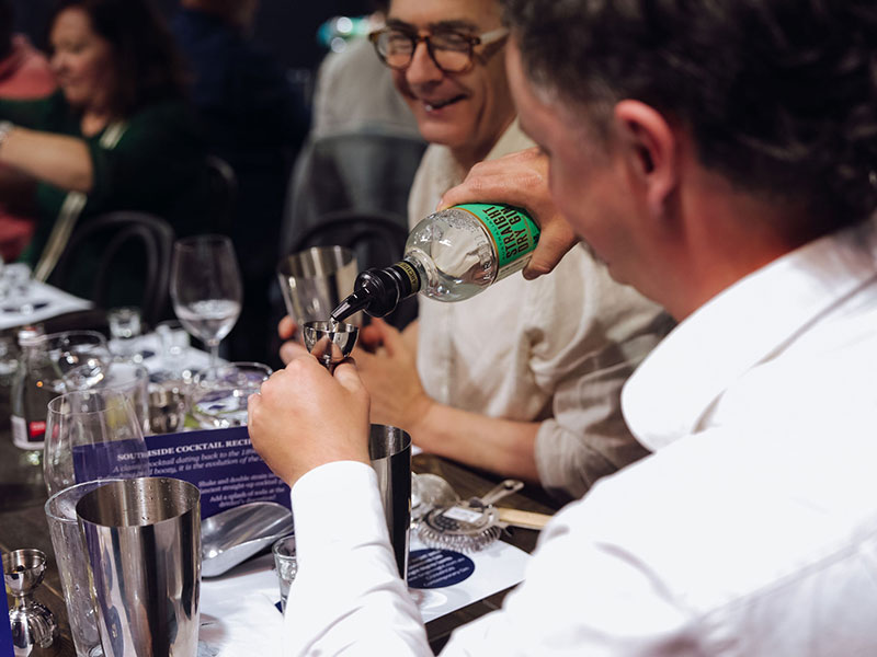 A man in a white shirt pours dry gin into a jigger during a masterclass at the Grape, Grain and Graze Festival.