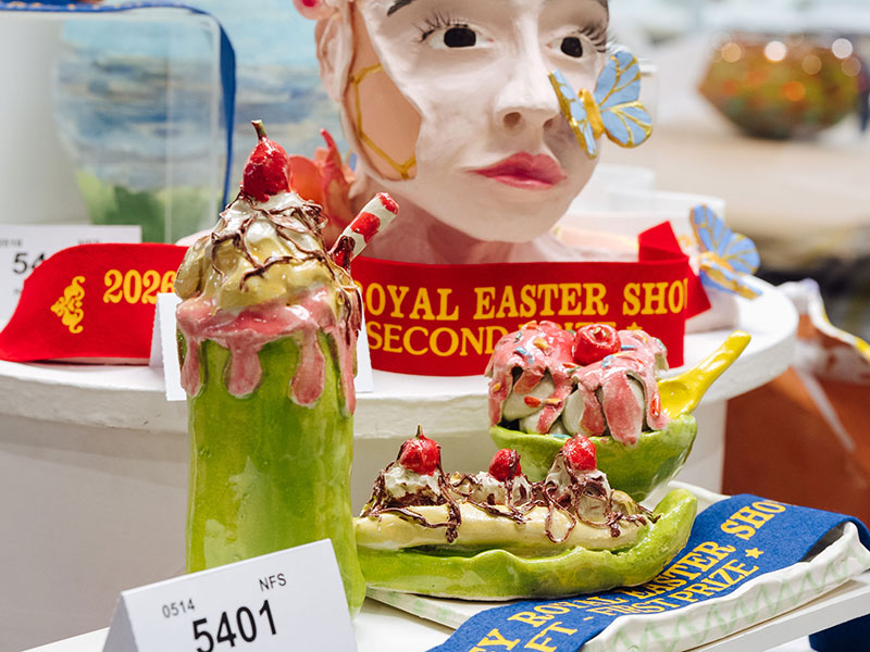 Ceramic sculptures of a whipped milkshake, ice cream and banana sundae in green vessels, on display at the Sydney Royal Arts & Crafts Show.